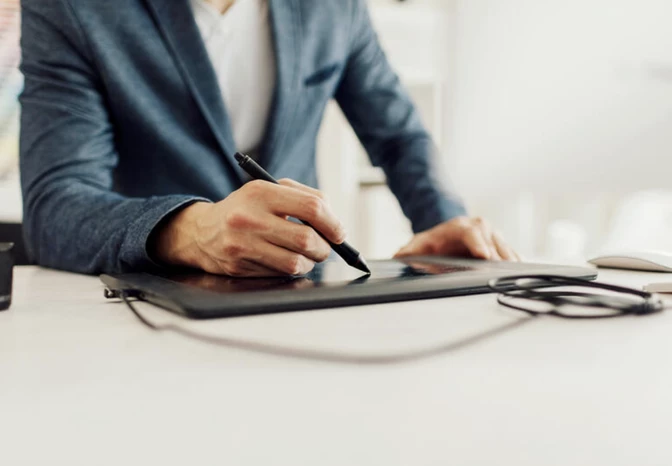 Business professional in navy blazer using stylus on digital graphics tablet, hands-on tech product demo