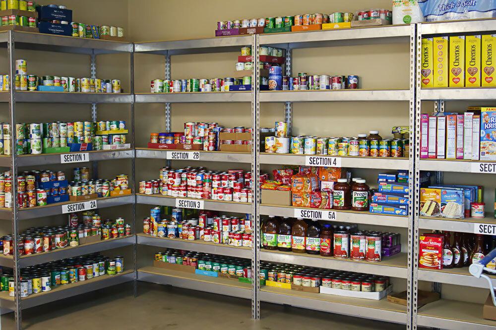 Organized food pantry shelving with multiple sections labeled 1-5A displaying canned goods, jarred items