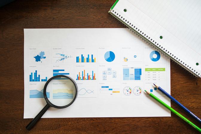 Business analytics dashboard printout with blue and orange charts, bar graphs, pie charts